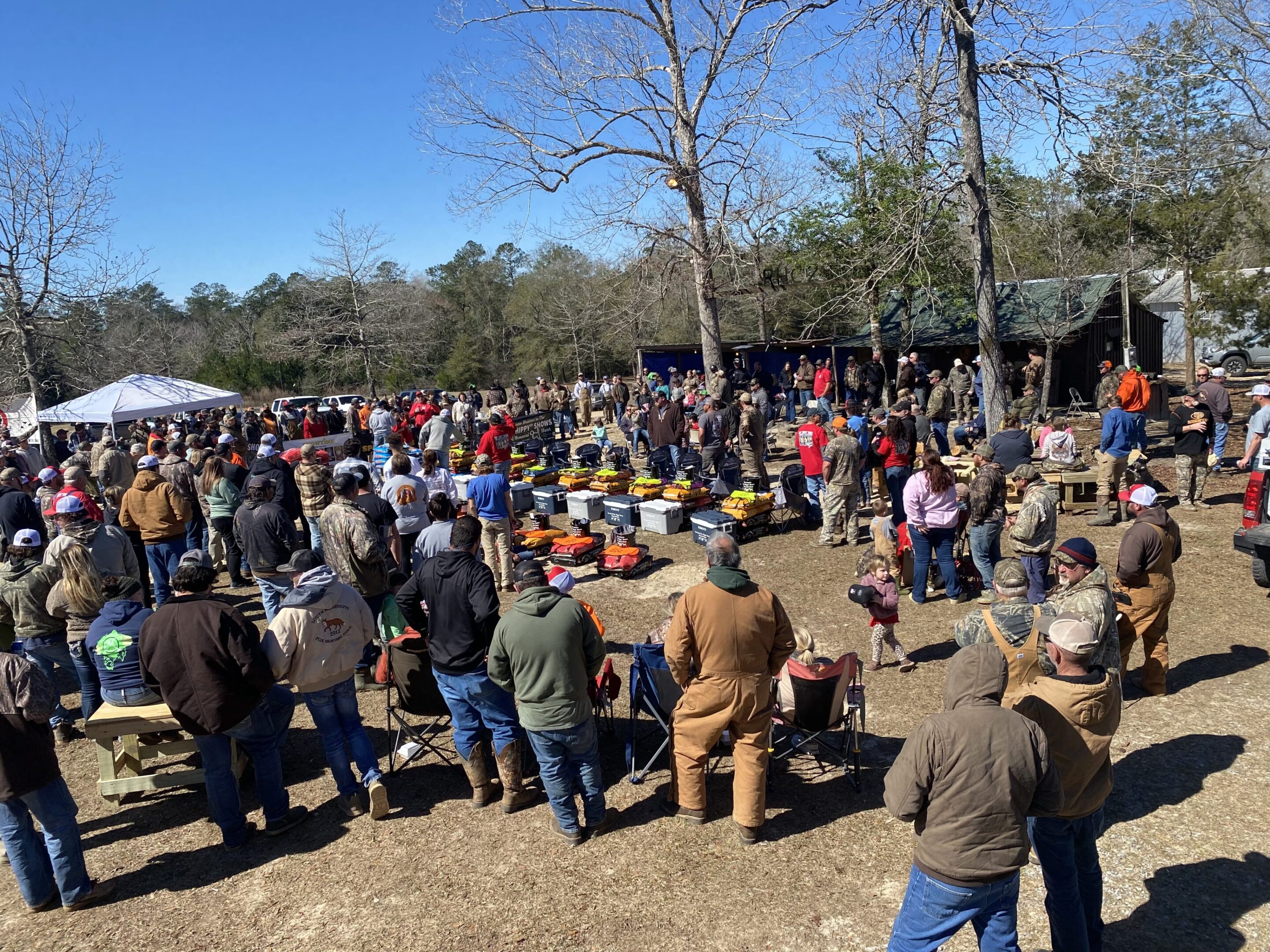 A large crowd of people gathered in the dirt.